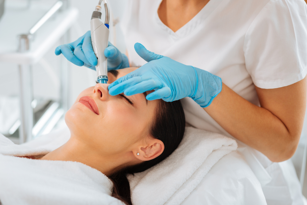 A woman having her facial treatment done by a professional